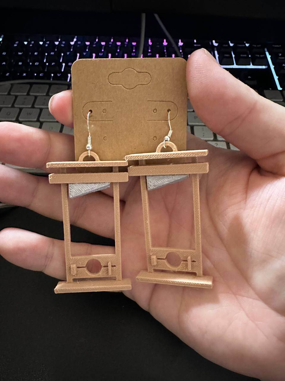 one pair of wooden guillotine earrings with a silver blade