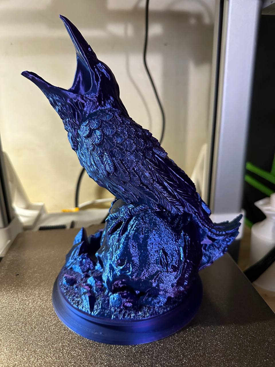 dice tower shaped like a raven sitting on top of a skull